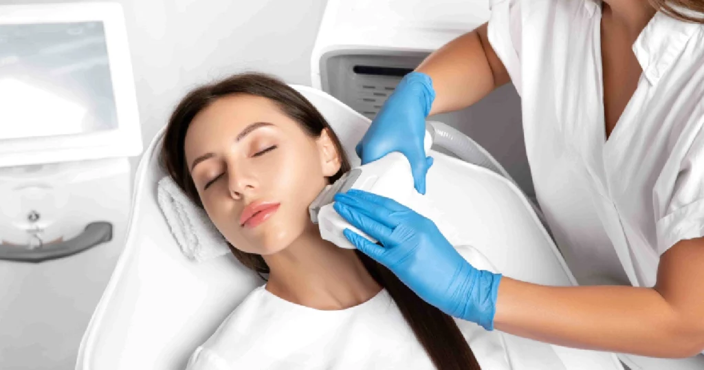A woman receives an IPL Photofacial on her jawline in Wichita, KS, from a professional in a modern clinic.