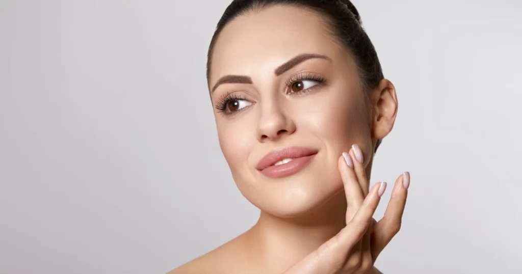 Woman touches her cheek during Plasmage Treatment in Wichita, KS.